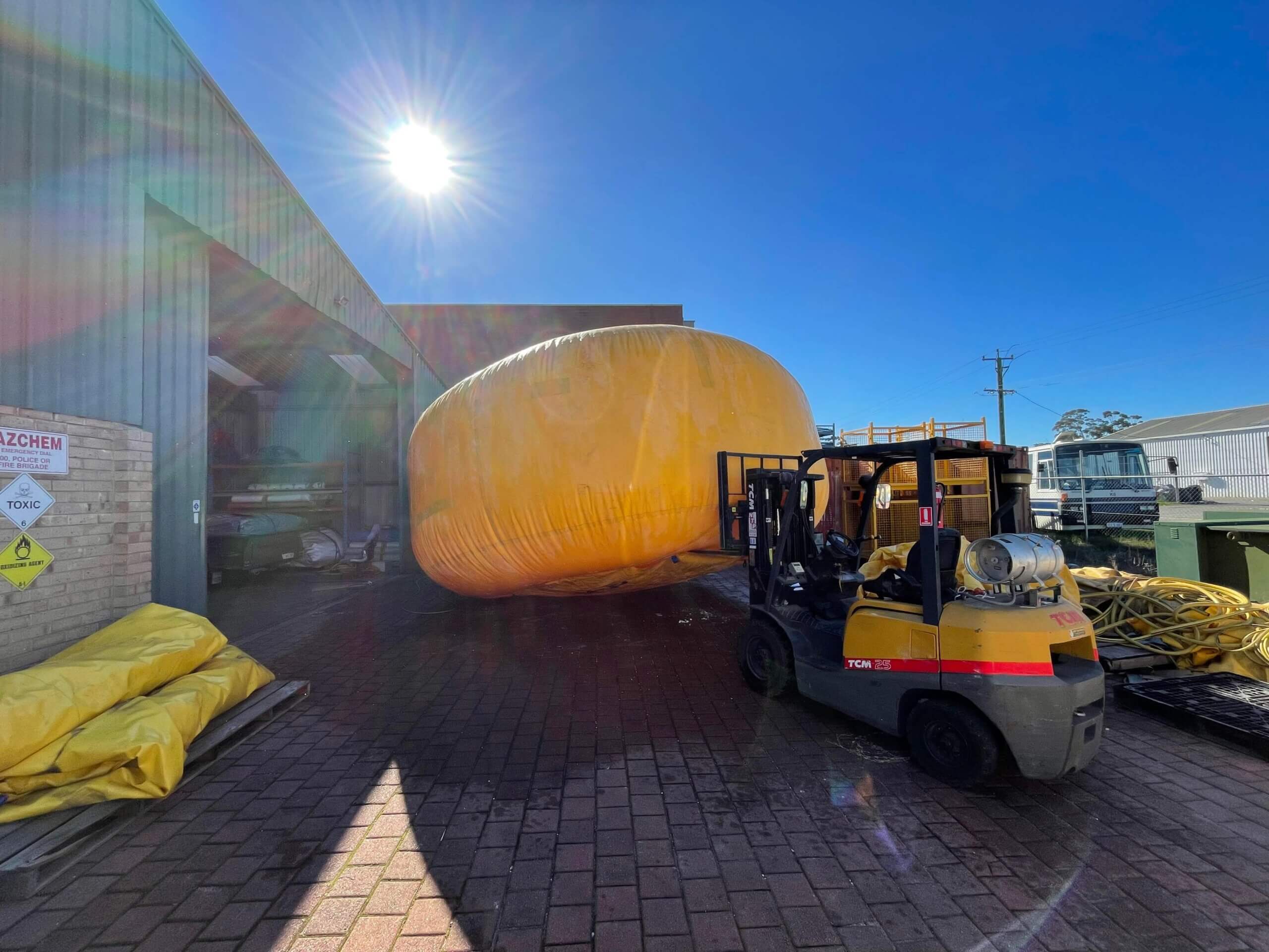 Inflated industrial inflatable being inspected before repair in the workshop.