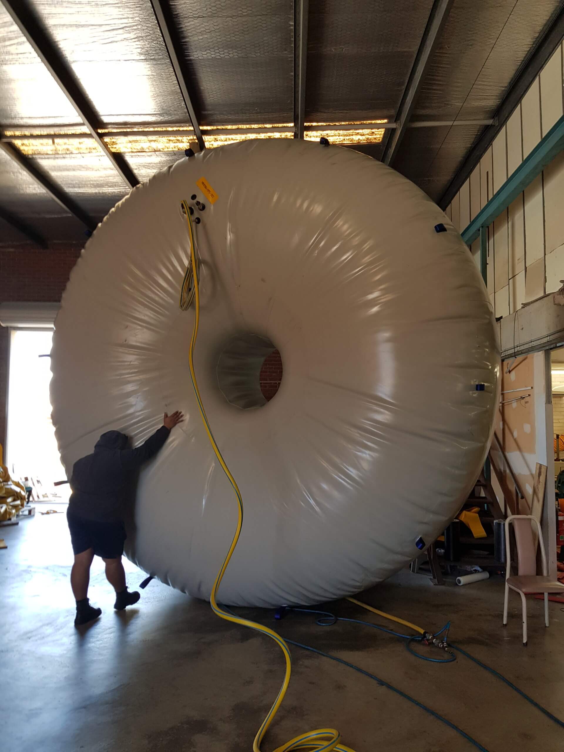 Technician inspecting a large industrial inflatable during pressure testing at the PolyFusion WA workshop.