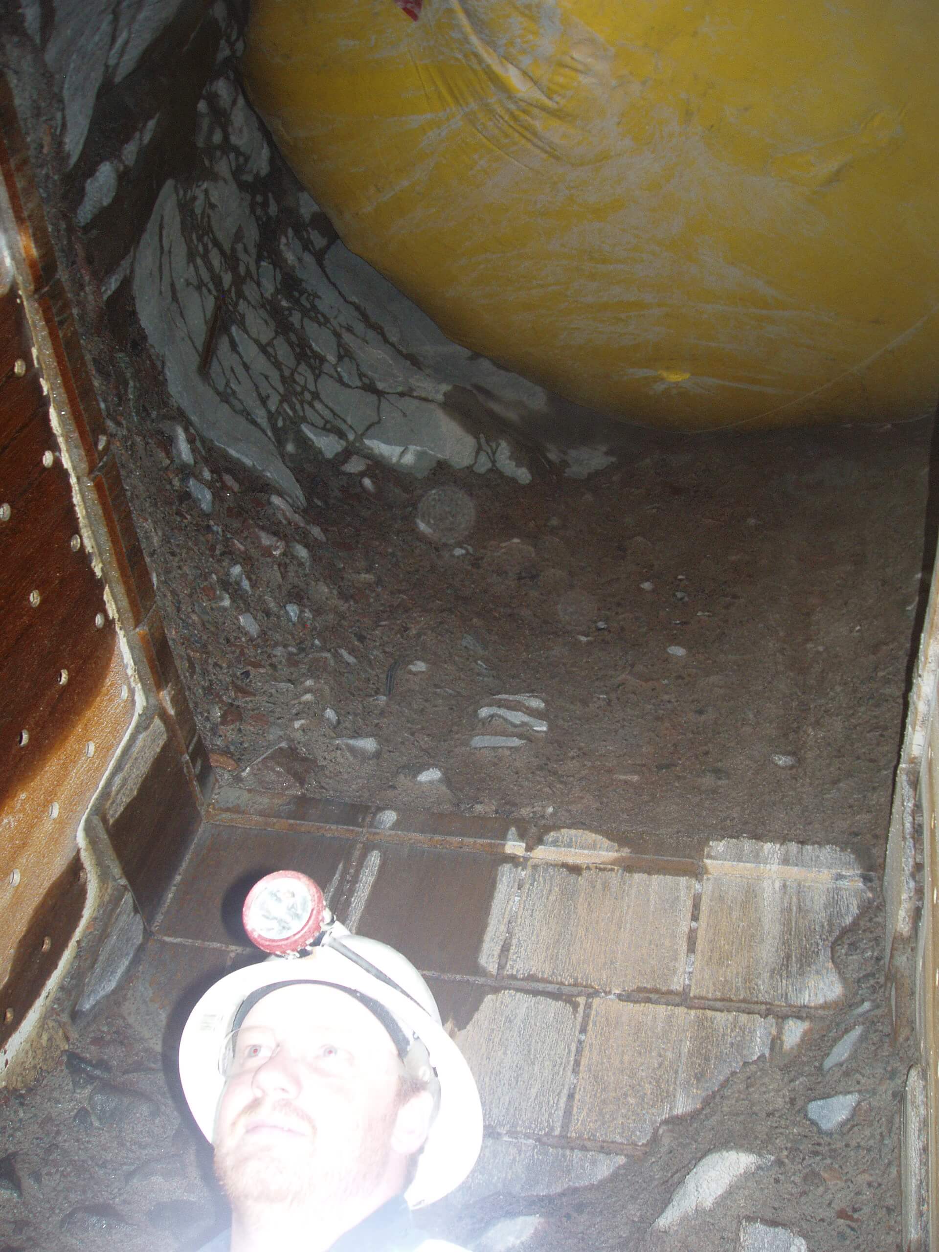 Inflatable overhead protection system being installed inside an underground mine ore pass.