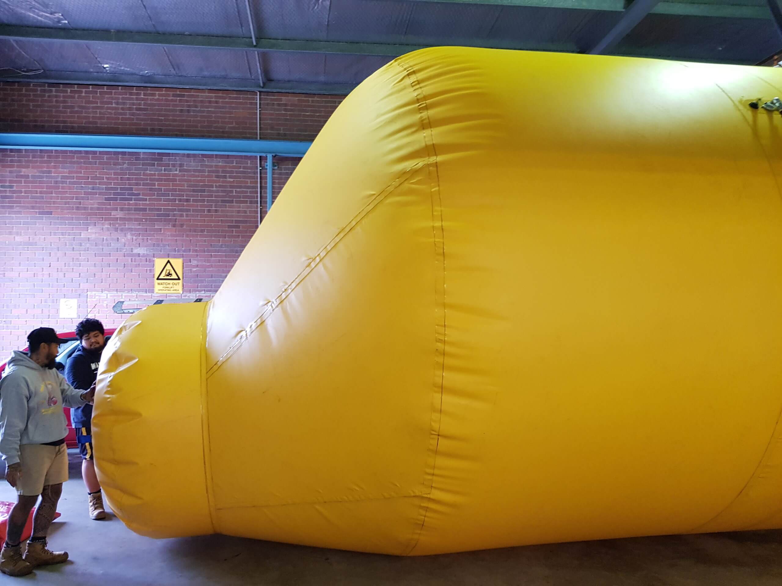 Custom shaped inflatable overhead protection system manufactured to suit an irregular industrial space.